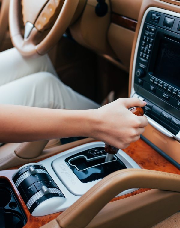 close up of woman shifting gears on gearbox in car